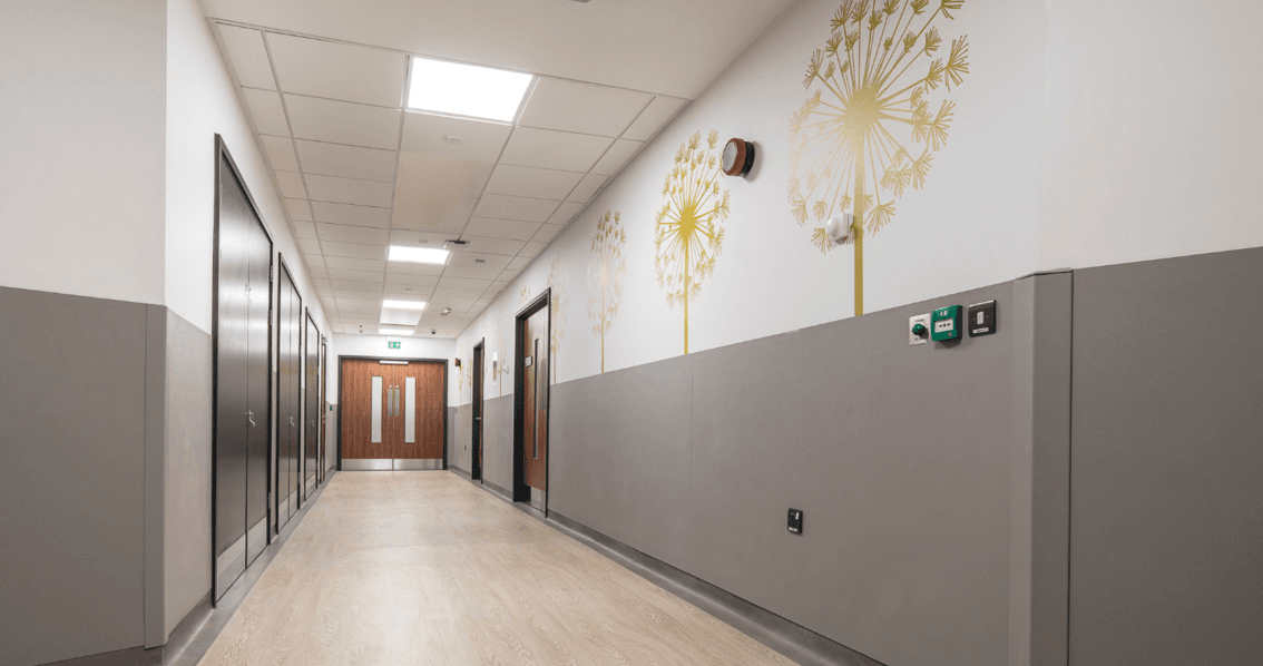 Couloir d'hôpital rénové avec panneaux muraux de protection et décoratif, réalisé par MARORENO.