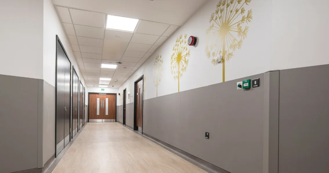 Couloir d'hôpital rénové avec panneaux muraux de protection et décoratif, réalisé par MARORENO.